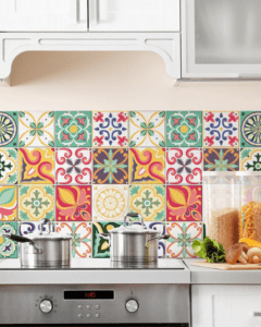 Rivestimento cucina con stampa colorata effetto piastrelle, applicato su parete tra piano cottura e pensili.