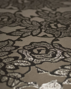 Stampa UV con effetto rilievo di fiori stilizzati neri su sfondo beige.