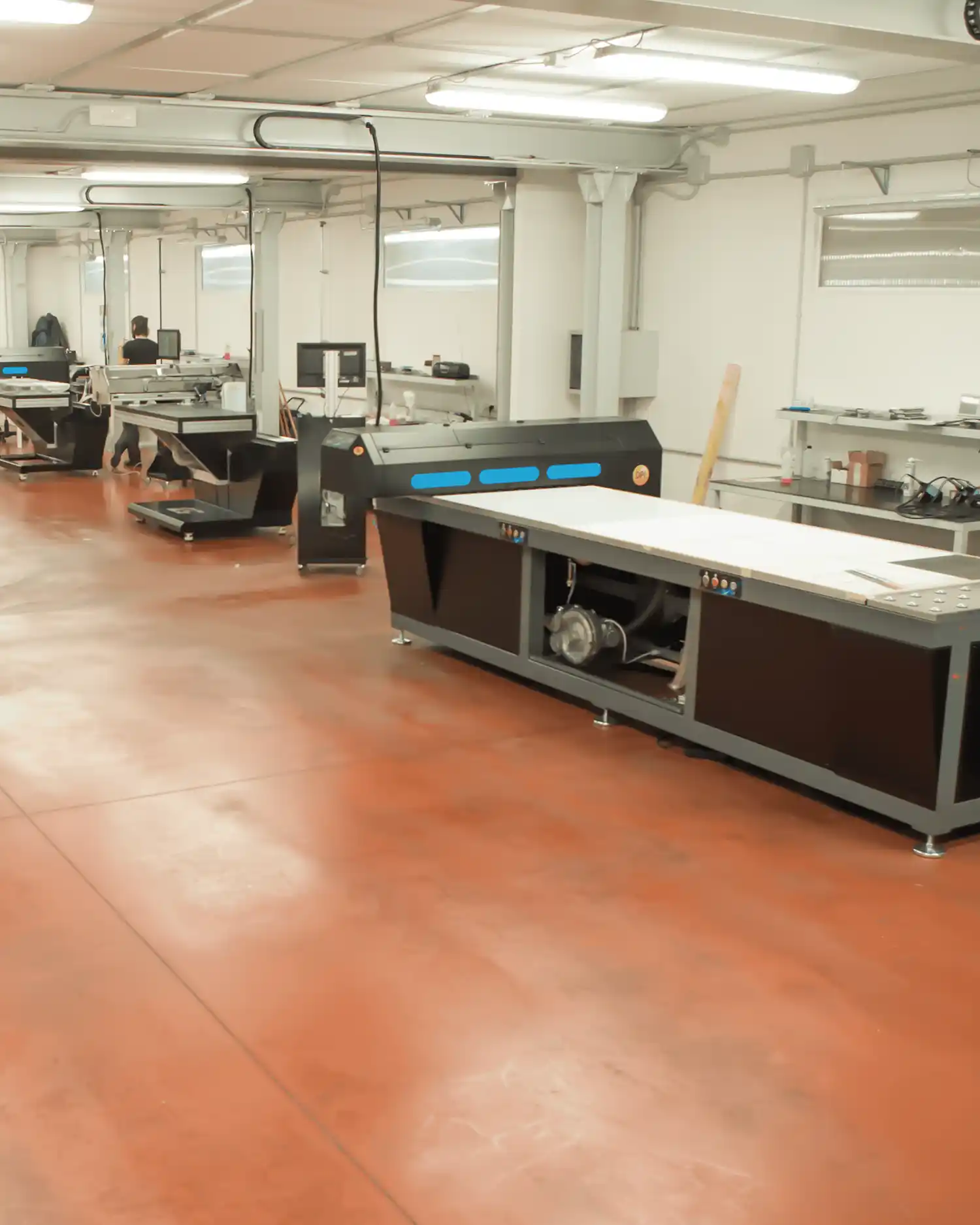 Linea_4.5 Línea de producción con impresoras industriales en un entorno limpio y organizado, con operarios trabajando.