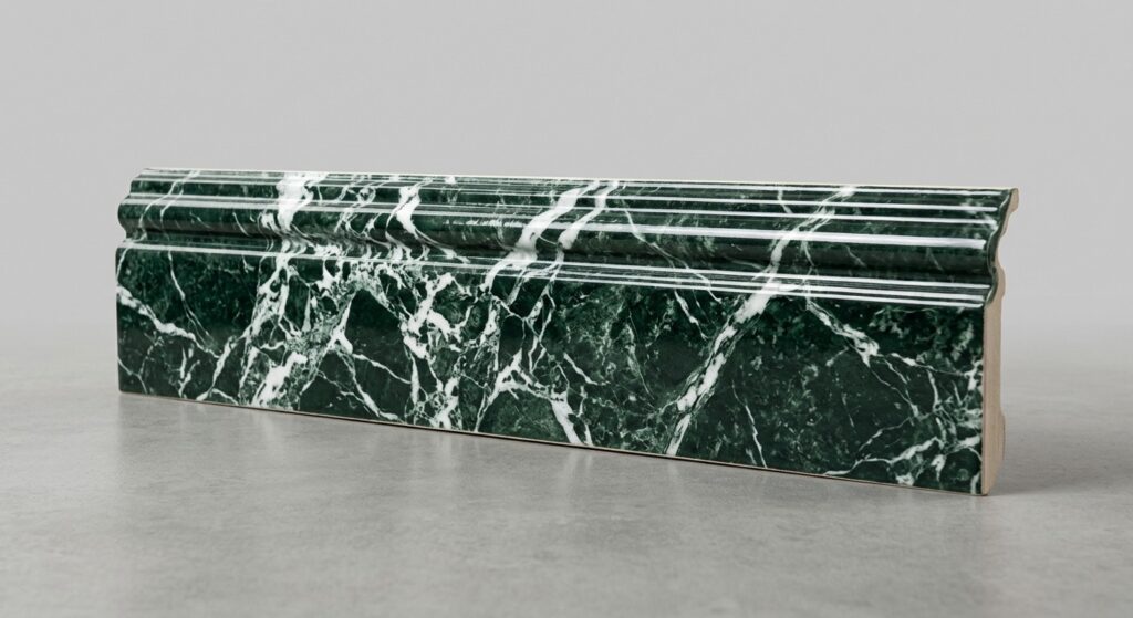 Battiscopa effetto marmo verde con venature bianche, profilo sagomato classico con doppia scanalatura.