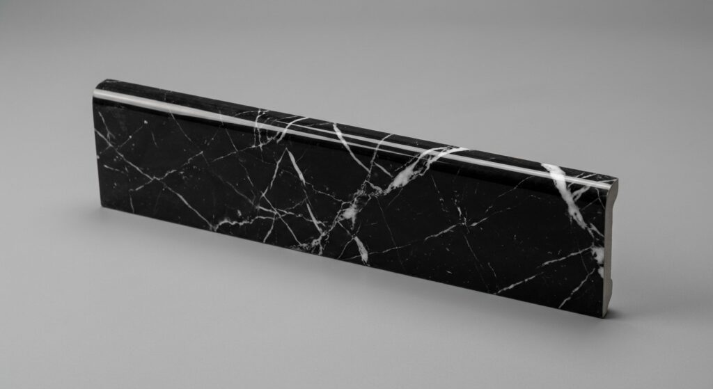 Battiscopa effetto marmo nero Marquina con venature bianche, profilo sagomato lucido.